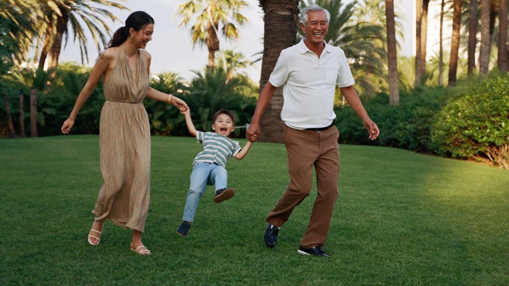 Three generations play on a sunlit lawn, the family that UK pension inheritance tax from 2027 would reach.